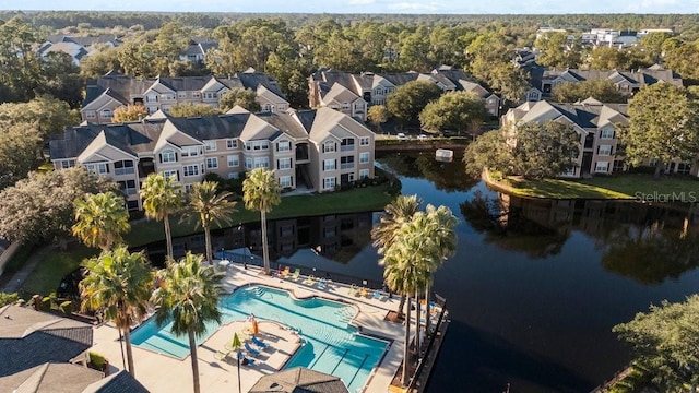 drone / aerial view of a pool area and a large body of water