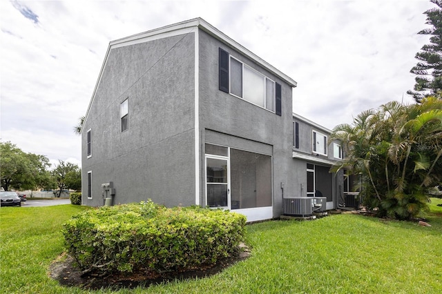 232 Countryside Key Blvd, Oldsmar, FL 34677 - rear view of property featuring stucco siding, central AC unit, and a yard
