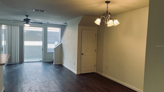 empty room featuring dark wood-style flooring, a chandelier, a ceiling fan, and baseboards