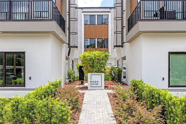 property entrance featuring stucco siding and a balcony