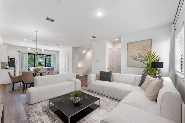 living room featuring wood finished floors, recessed lighting, and stairs