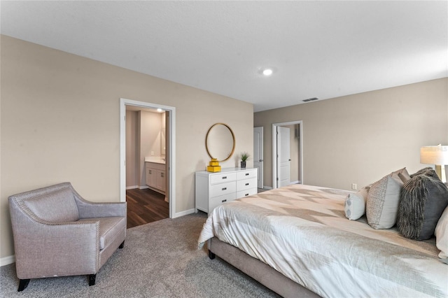bedroom with carpet flooring, baseboards, and connected bathroom