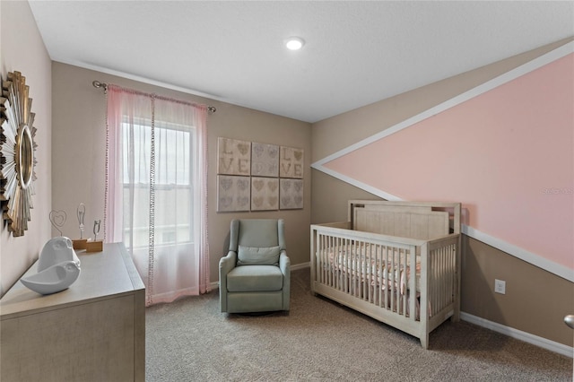 bedroom featuring carpet, a nursery area, and baseboards
