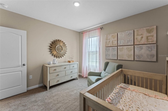carpeted bedroom with a nursery area and baseboards