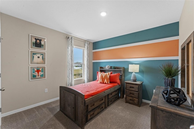 carpeted bedroom featuring baseboards and an office area