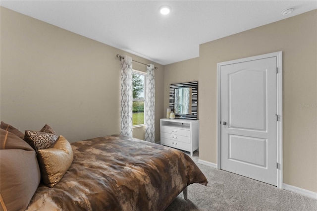 bedroom featuring light carpet and baseboards