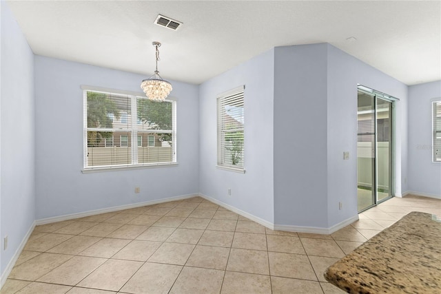 unfurnished dining area featuring light tile patterned floors, healthy amount of natural light, a chandelier, and baseboards