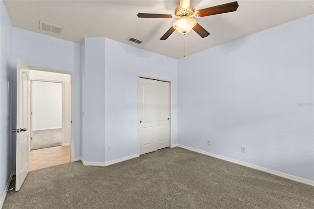 unfurnished bedroom with carpet floors, baseboards, a closet, and a ceiling fan