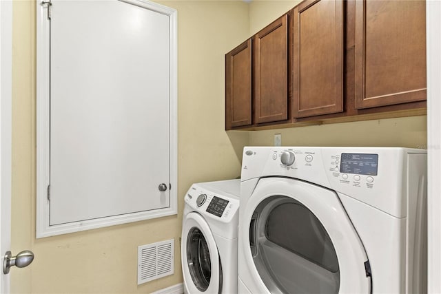 laundry area featuring washer and clothes dryer and cabinet space