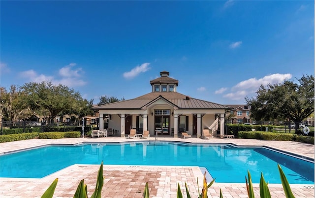 community pool featuring fence and a patio area