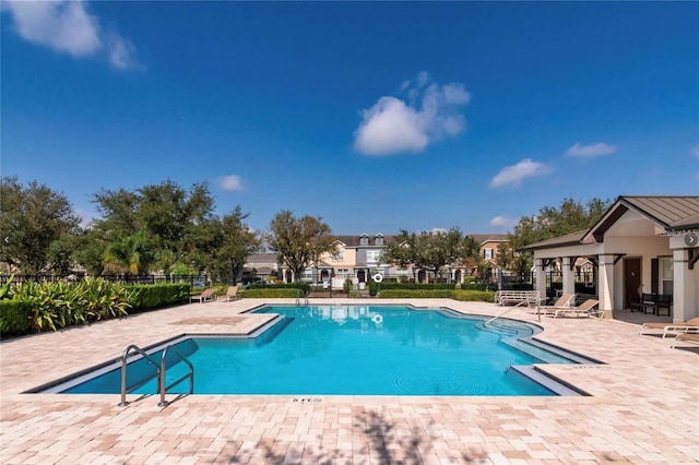 community pool with a patio and fence