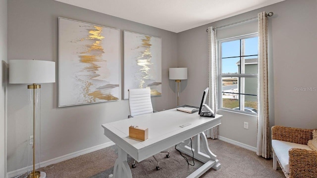 carpeted home office with healthy amount of natural light and baseboards