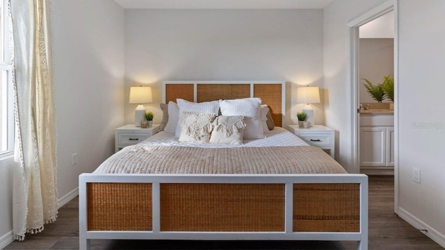 bedroom with wood finished floors, baseboards, and ensuite bathroom