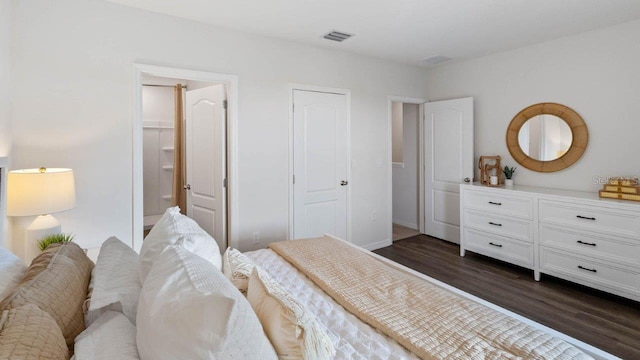 bedroom featuring dark wood-type flooring and ensuite bath