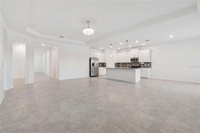 6139 Claystone Way, Mount Dora, FL 32757 - unfurnished living room with recessed lighting, a raised ceiling, and baseboards
