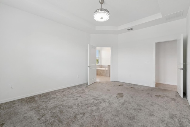 6139 Claystone Way, Mount Dora, FL 32757 - unfurnished bedroom featuring carpet flooring, a tray ceiling, baseboards, and ensuite bathroom