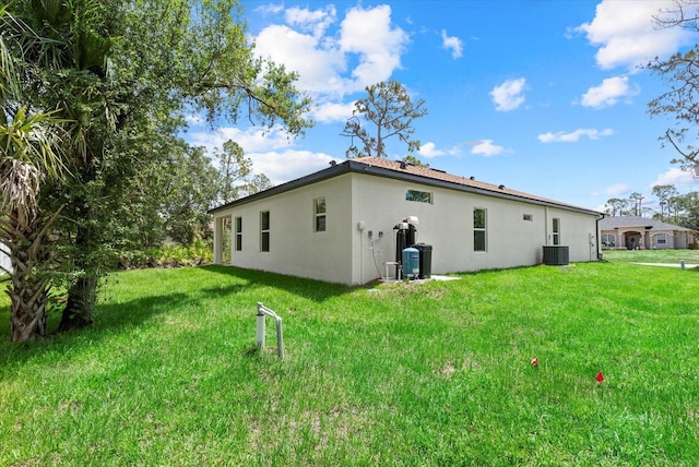 2919 Cascabel Ter, North Port, FL 34286 - rear view of property with stucco siding, central air condition unit, and a lawn