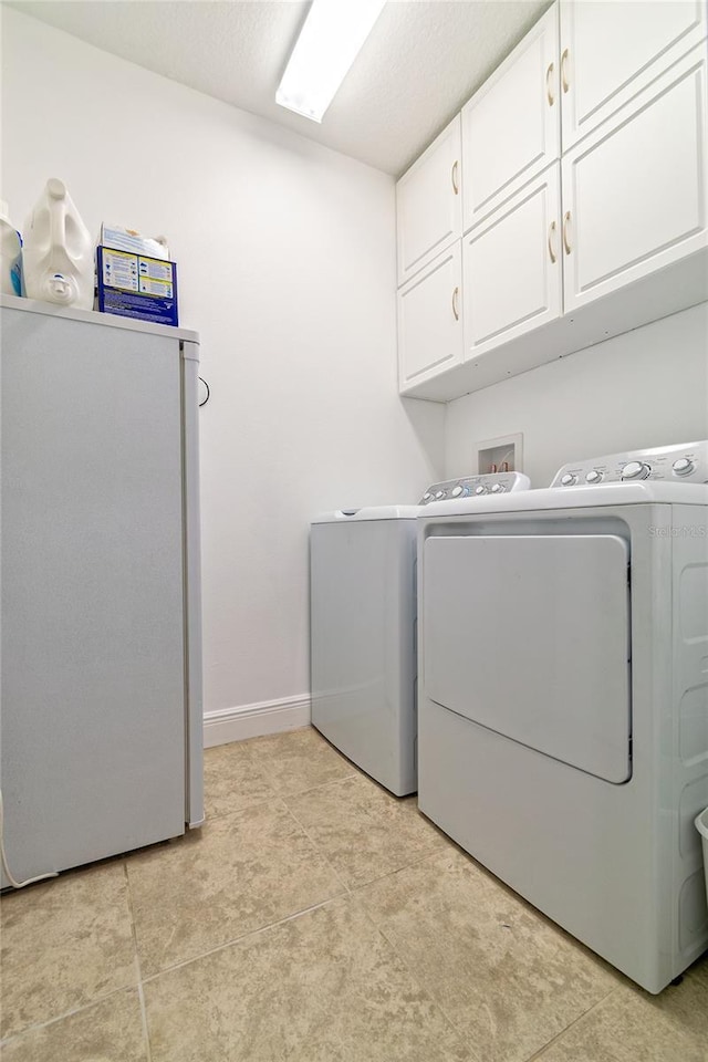 109 Kenny Blvd, Haines City, FL 33844 - laundry area featuring cabinet space, separate washer and dryer, baseboards, and light tile patterned flooring