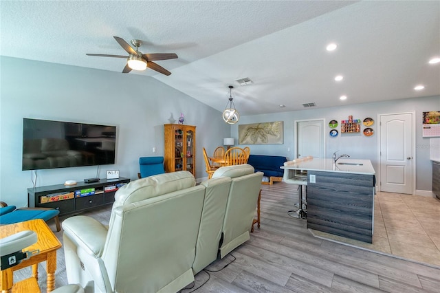 109 Kenny Blvd, Haines City, FL 33844 - living room featuring vaulted ceiling, ceiling fan, recessed lighting, light wood-style flooring, and a textured ceiling