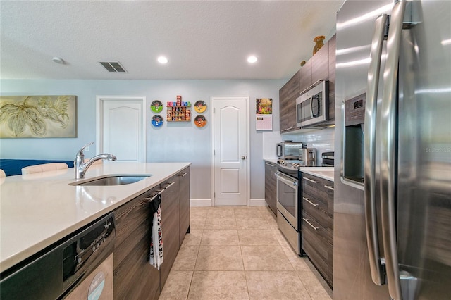 109 Kenny Blvd, Haines City, FL 33844 - kitchen featuring stainless steel appliances, a sink, light countertops, modern cabinets, and recessed lighting