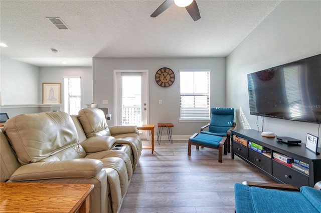 109 Kenny Blvd, Haines City, FL 33844 - living area with light wood-style flooring, ceiling fan, a textured ceiling, and baseboards