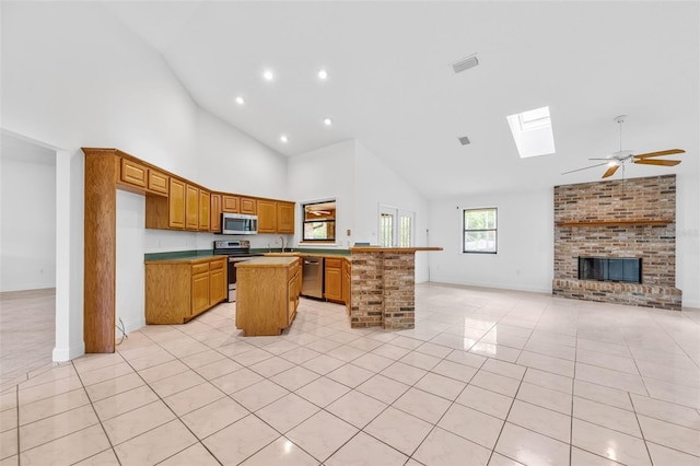 4206 Hield Rd NW, Palm Bay, FL 32907 - kitchen featuring stainless steel appliances, high vaulted ceiling, a kitchen island, open floor plan, and a skylight