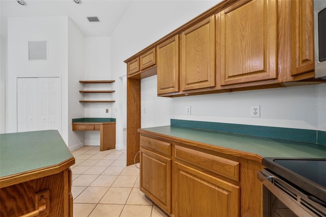 4206 Hield Rd NW, Palm Bay, FL 32907 - kitchen featuring brown cabinetry, light tile patterned floors, dark countertops, open shelves, and electric stove