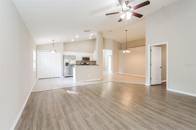 24237 Rolling View Ct, Lutz, FL 33559 - unfurnished living room featuring light wood-type flooring, baseboards, a ceiling fan, and high vaulted ceiling