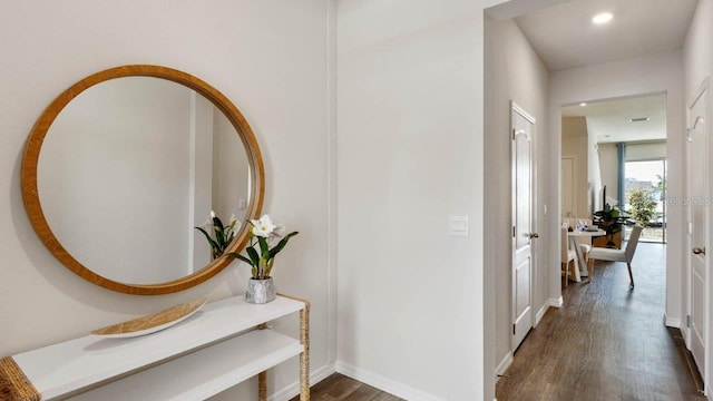 hallway with dark wood-style flooring, baseboards, and recessed lighting