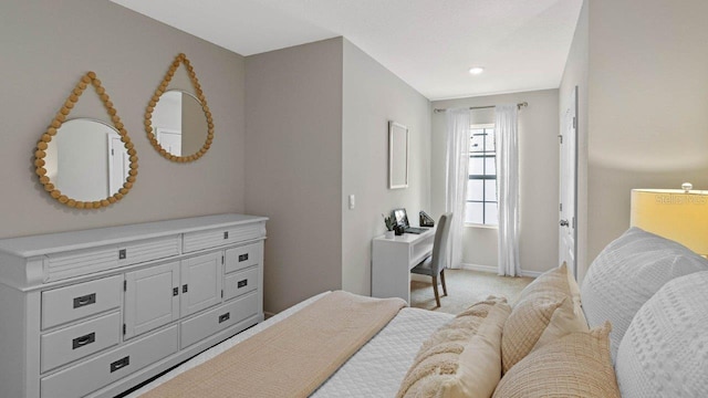 bedroom with light colored carpet and baseboards
