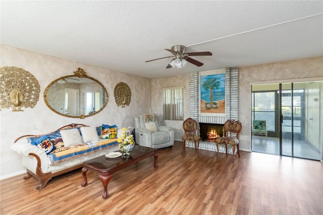 6 Escondido Cir Unit 55, Altamonte Springs, FL 32701 - living room with a textured ceiling, wood finished floors, ceiling fan, a fireplace, and baseboards