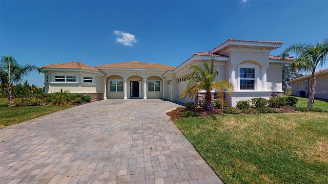 8851 Fallen Oak Dr, Davenport, FL 33896 - mediterranean / spanish home with decorative driveway, an attached garage, a tiled roof, and stucco siding