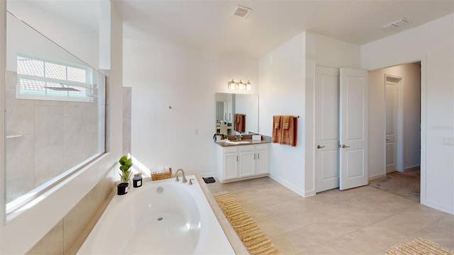 8851 Fallen Oak Dr, Davenport, FL 33896 - full bathroom featuring a garden tub, vanity, a walk in shower, and tile patterned flooring