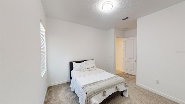8851 Fallen Oak Dr, Davenport, FL 33896 - bedroom with light carpet, a textured ceiling, and baseboards