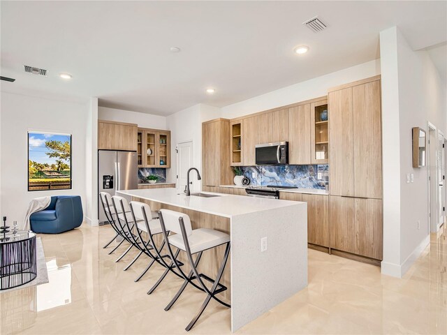 2545 NW 22nd Pl, Cape Coral, FL 33993 - kitchen featuring stainless steel appliances, a sink, modern cabinets, decorative backsplash, and a breakfast bar area