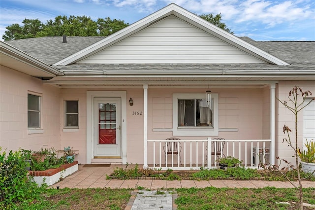 3162 Little Sound Dr, Orlando, FL 32827 - view of exterior entry with a shingled roof and a porch