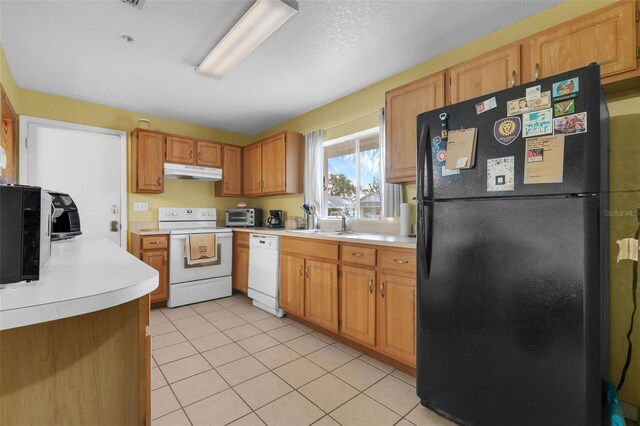 3162 Little Sound Dr, Orlando, FL 32827 - kitchen with white appliances, under cabinet range hood, light countertops, a sink, and light tile patterned flooring