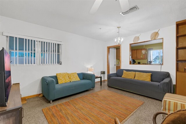 3162 Little Sound Dr, Orlando, FL 32827 - living area featuring speckle patterned floor, a ceiling fan, baseboards, and a chandelier