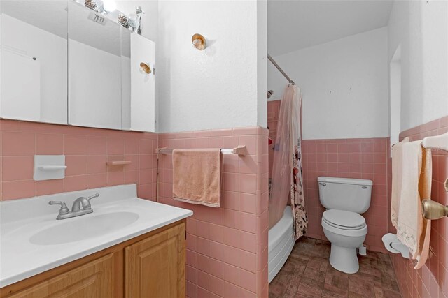 3162 Little Sound Dr, Orlando, FL 32827 - bathroom with tile walls, toilet, a wainscoted wall, shower / bathtub combination with curtain, and vanity