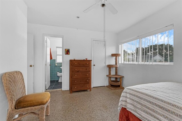 3162 Little Sound Dr, Orlando, FL 32827 - bedroom with speckle patterned floor, ensuite bathroom, tile walls, and ceiling fan