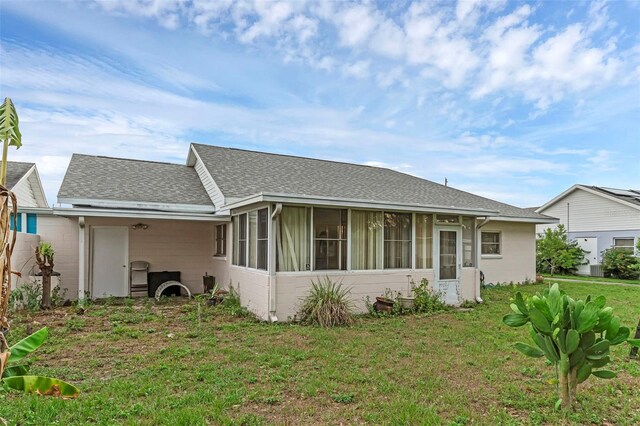 3162 Little Sound Dr, Orlando, FL 32827 - rear view of property featuring a sunroom, a shingled roof, and a yard