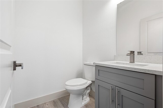 13163 SW 70th Ct, Ocala, FL 34473 - half bathroom with toilet, wood finished floors, vanity, and baseboards