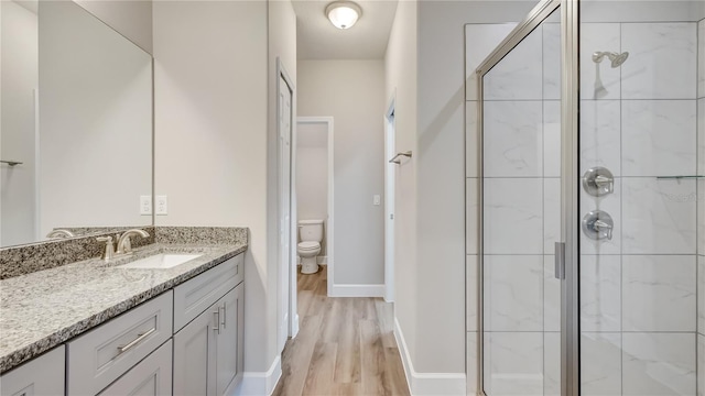 8560 Magnificent Ln, Groveland, FL 34736 - bathroom featuring a stall shower, wood finished floors, vanity, and toilet