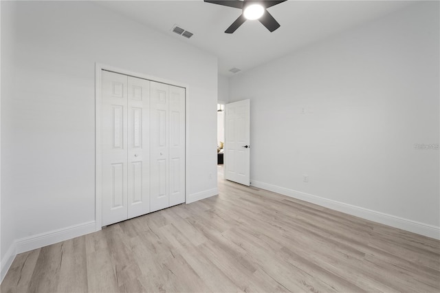unfurnished bedroom featuring light wood-type flooring, a closet, baseboards, and a ceiling fan