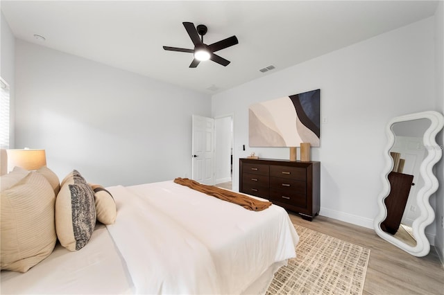 bedroom with light wood-type flooring, baseboards, and ceiling fan
