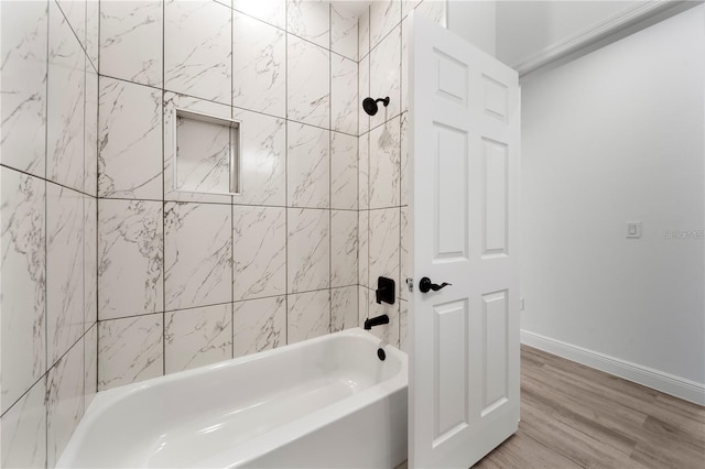 full bath featuring baseboards, wood finished floors, and tub / shower combination