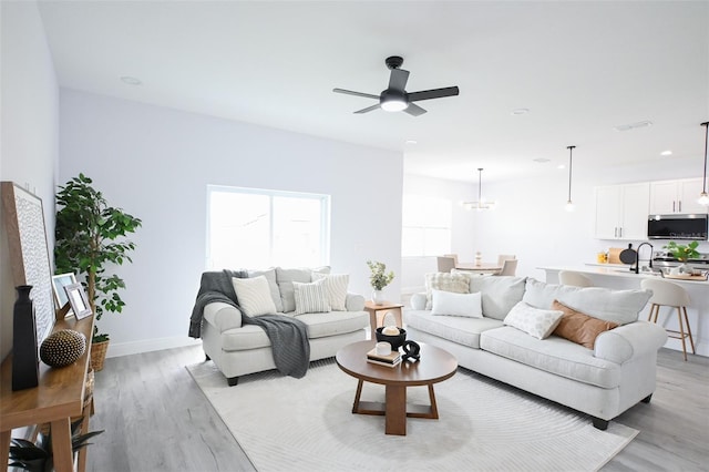 921 Sable Cir SE, Palm Bay, FL 32909 - living room with light wood-style floors, a ceiling fan, baseboards, a chandelier, and recessed lighting