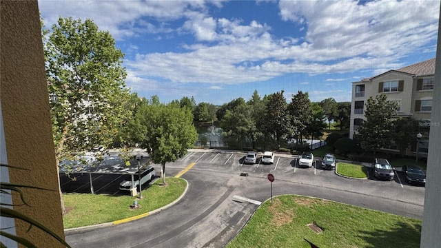 view of asphalt road featuring curbs and traffic signs