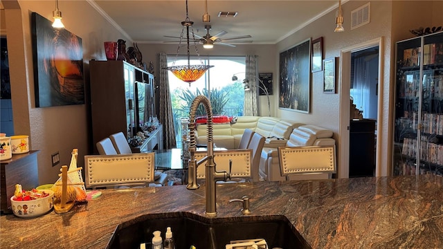 dining space featuring a ceiling fan and crown molding