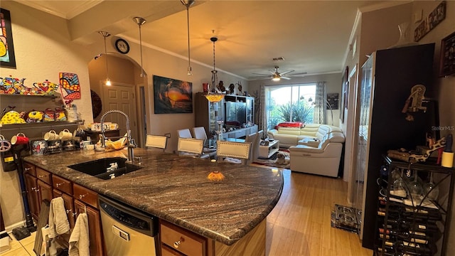 kitchen featuring dishwashing machine, a sink, crown molding, ceiling fan, and arched walkways